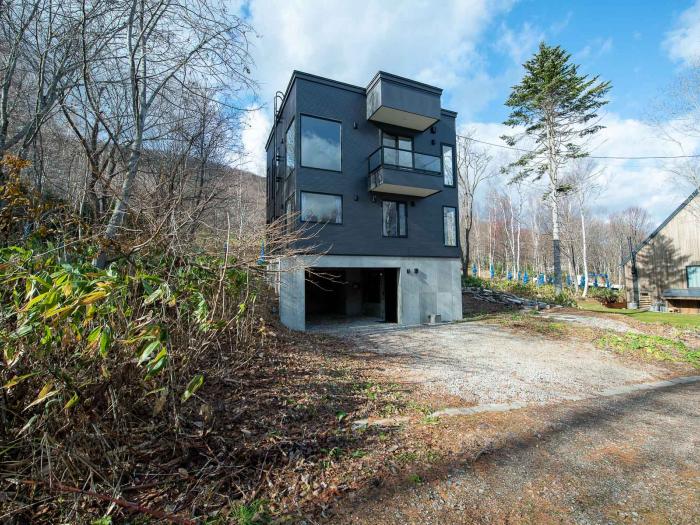 Ebisu exterior A large 3 story house with grey siding.