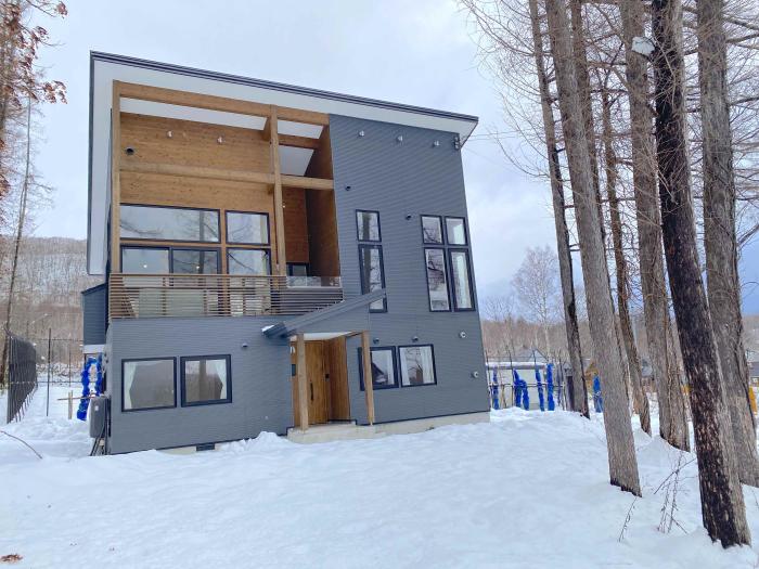 Hibiki Exterior A two story home with trees to the right and snow in the foreground
