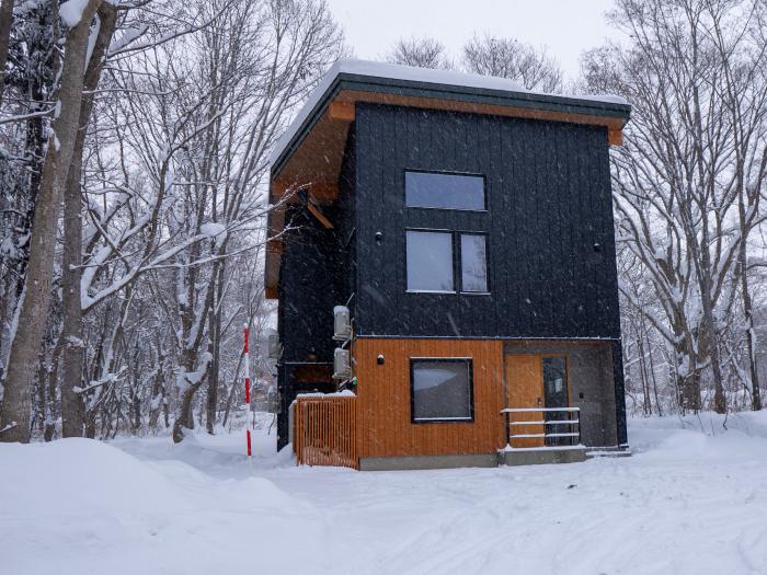 An exterior shot of a two story house with wood and steel cladding