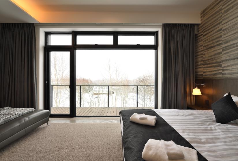 view from bedroom with wall high windows and black curtains