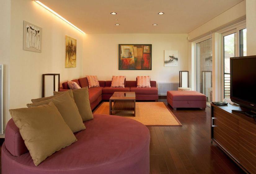 living room with red couches coffee table and carpet with paintings