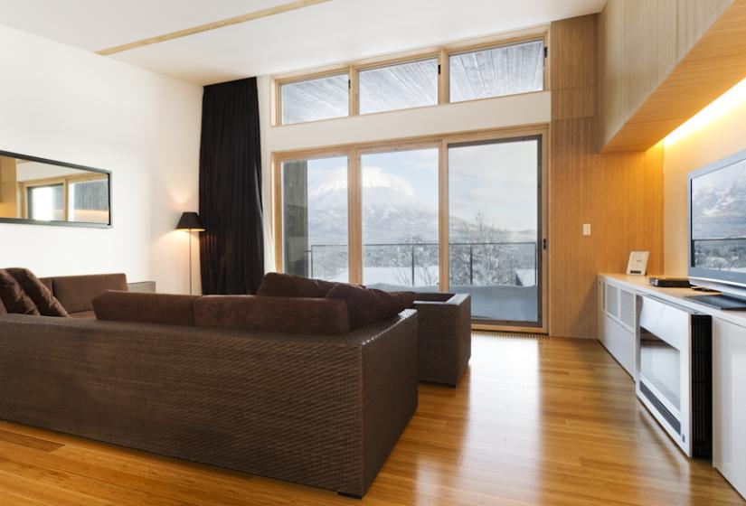 living area with brown sofas, tv, and view of Mt. Yotei 