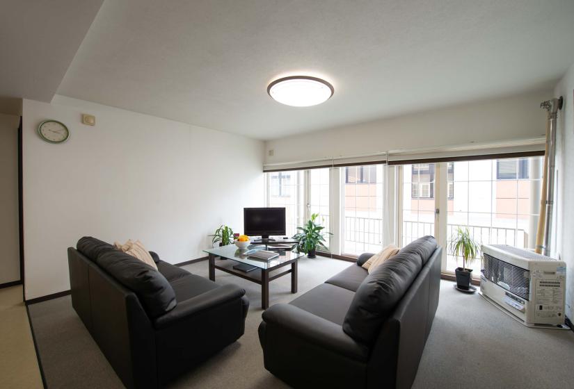 2 black sofas and lass coffee table