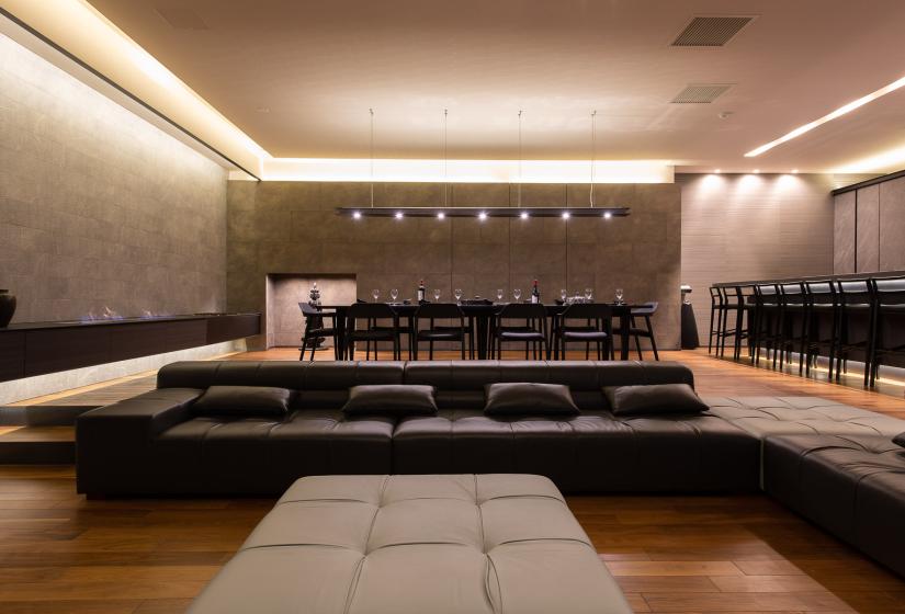 A black lounge suite with dining table behind