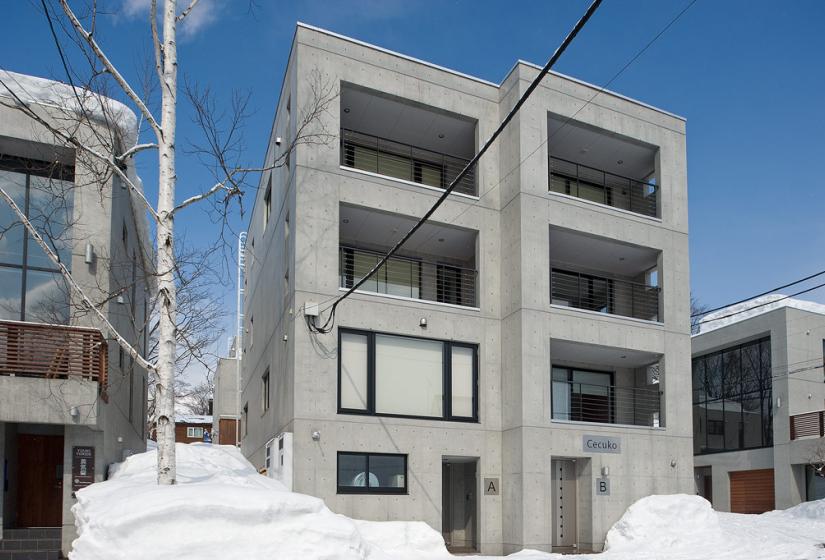 Concrete apartments with large window in snowy back drop