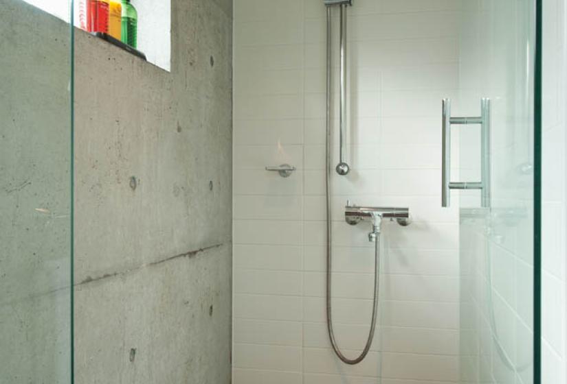 shower with concrete walls and glass door
