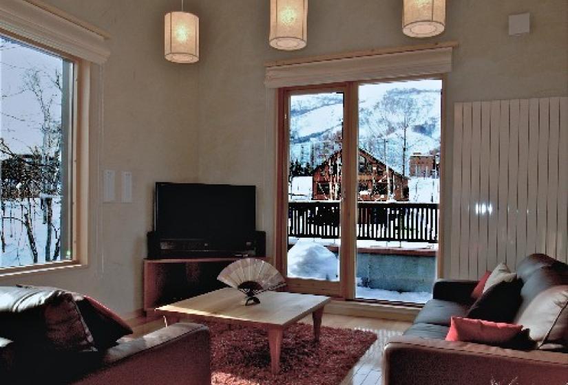Genji living area with sofas, tv, and winter view