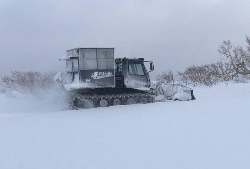 A black snow cat in action