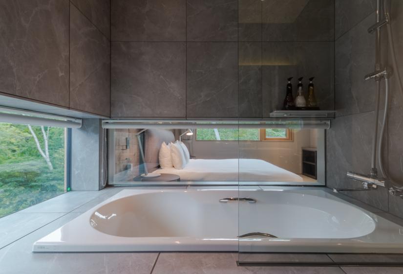 bathtub with window to main bedroom