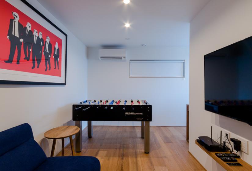 couch, foosball, air conditioner with small table and TV
