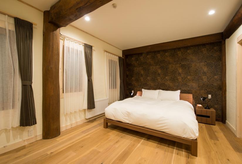 Double bed on natural wood floor