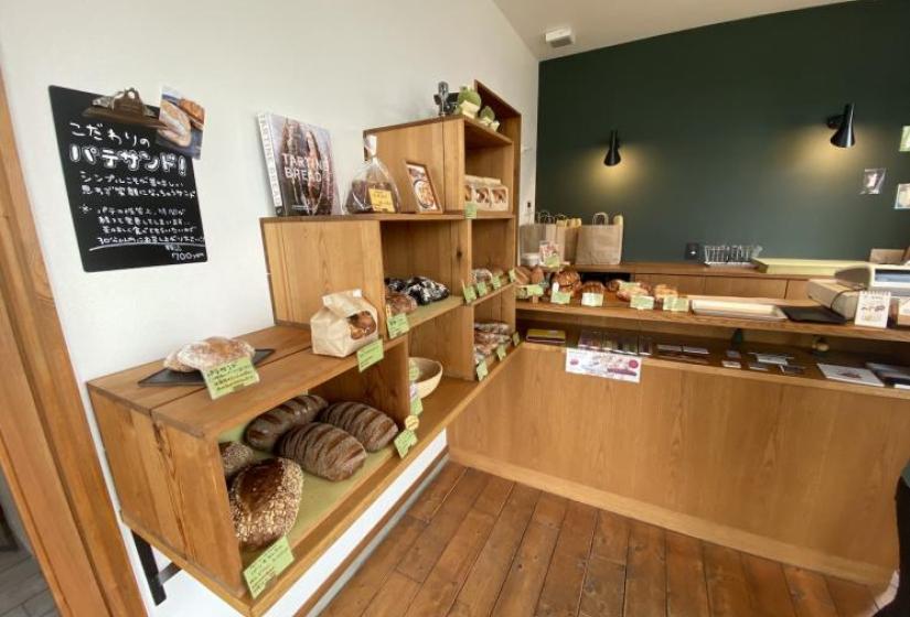 The interior of a stylish bakery with shelves of bread