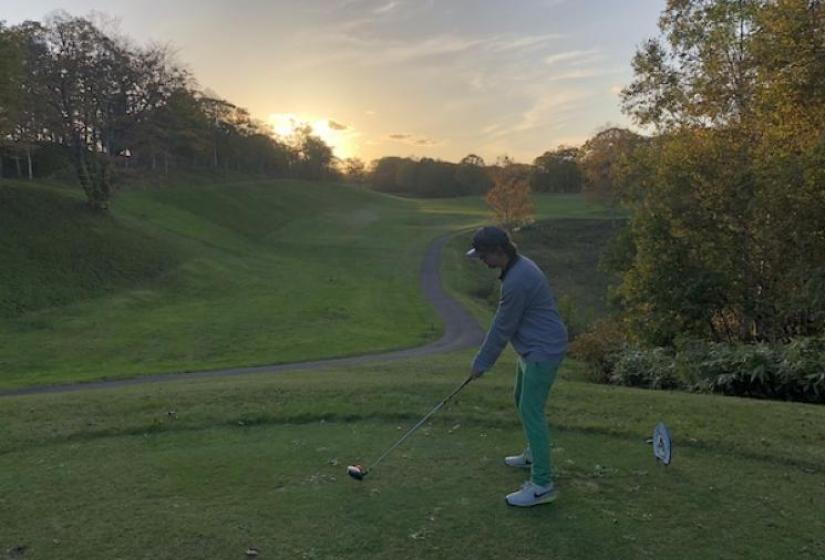A golfer tees off into the sunset
