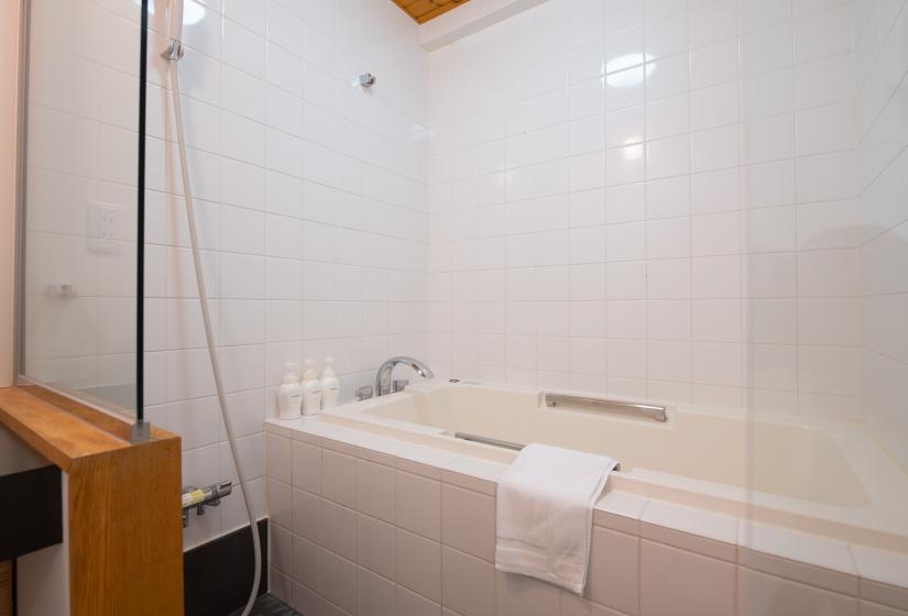 Sakura bathroom with white towel and shower head