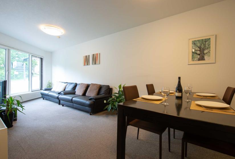 Living room view with table set and 2 black sofas
