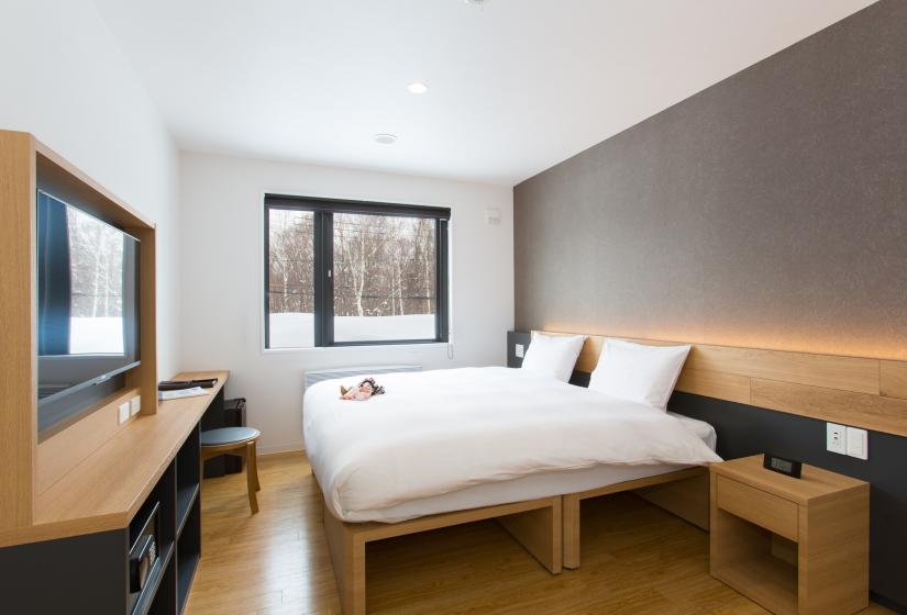 Hotel room with wooden floor and two white beds