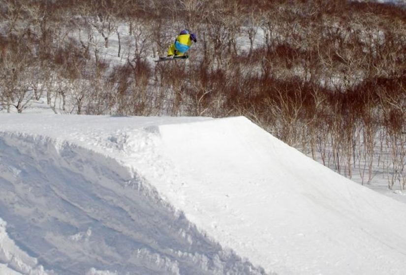 A skier hitting a hip jump.