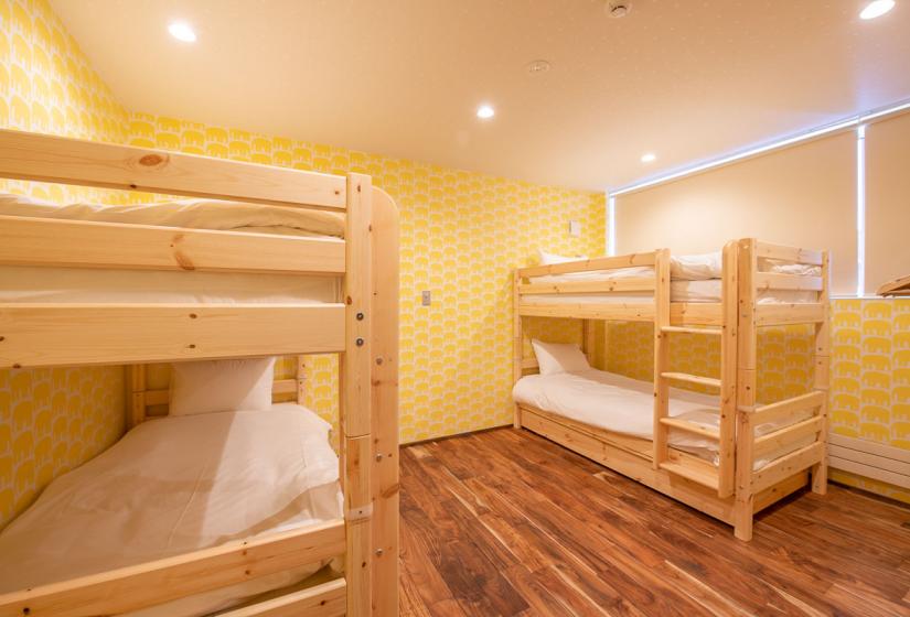 Two wooden bunks in yellow wallpapered room
