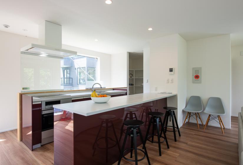 web.jpg	An island bench with 3 black stools and kitchen behind