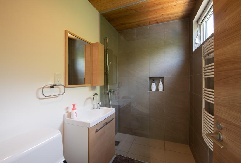 A bathroom sink and tiled shower behind.