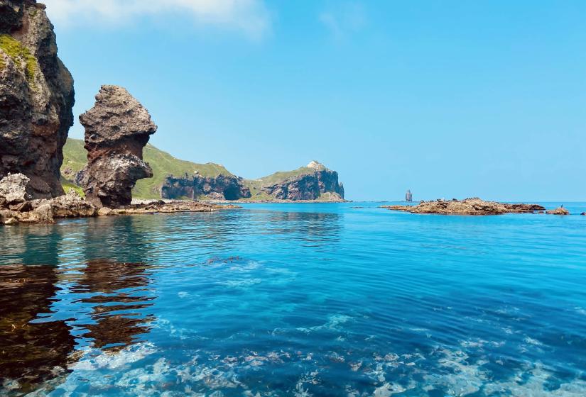 Shakotan's hallow clear blue water with cliffs behind.