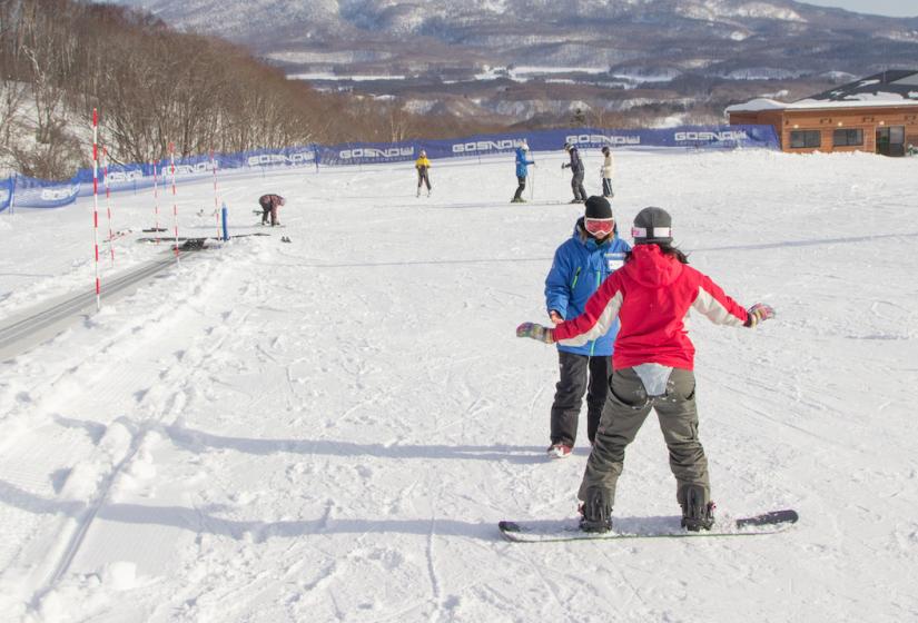 March is an excellent time to learn to ski or snowboard. A snowboarder takes a private lesson