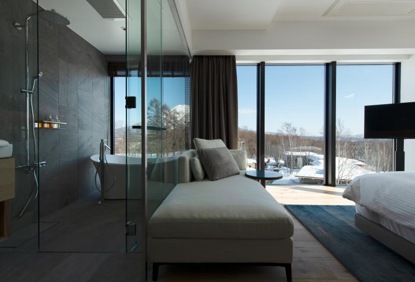 A bedroom and bathroom with large windows