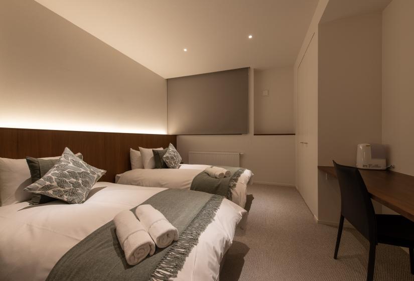 Two single beds with a grey throw