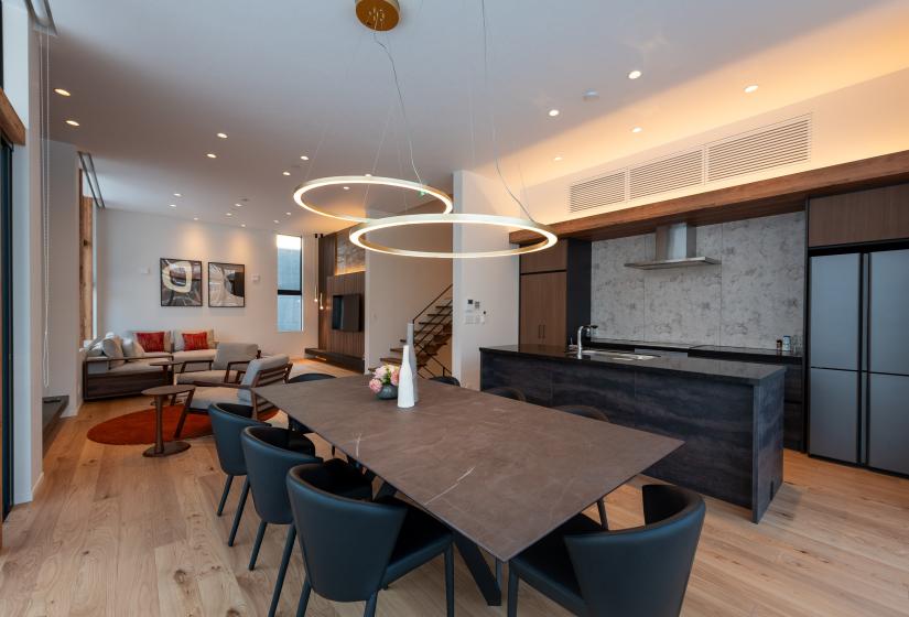 A dining table with large lights above   