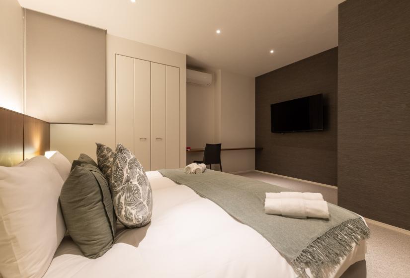 A double bed with grey throw