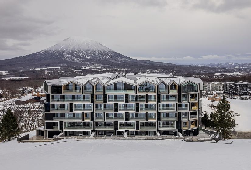 The exterior of a 6 story hotel with Yotei behind 