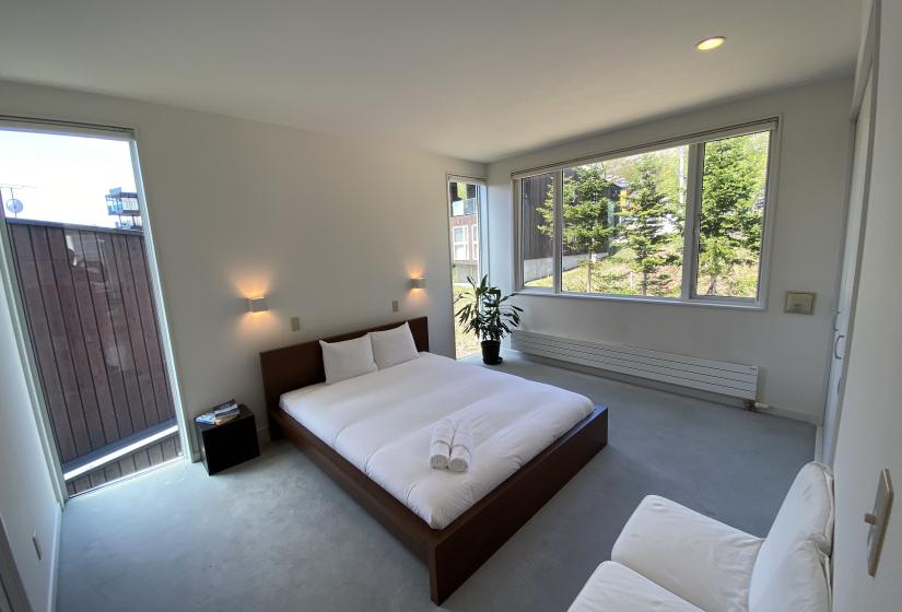 A double bed with plant to the right