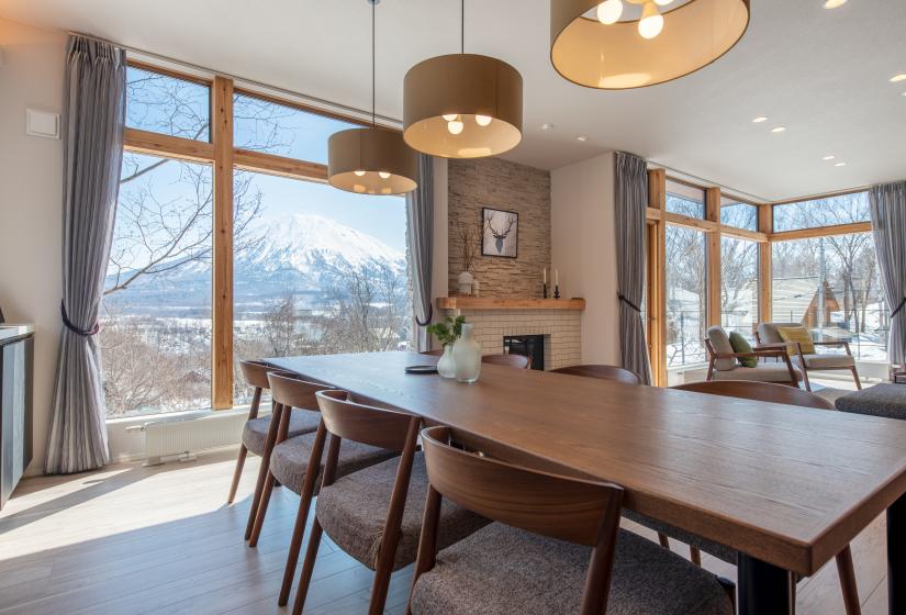 A dining table with hanging lights above