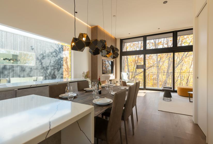 A white kitchen bench with dining table behind