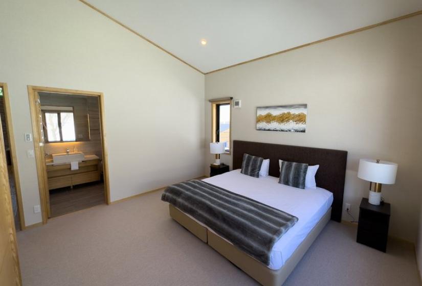 Niseko luxury king bedroom at Chalet Taiko featuring split king bed and private ensuite doorway
