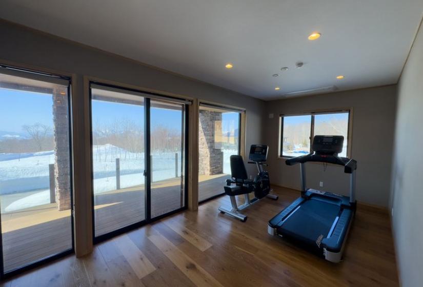 Niseko Chalet Taiko's private gym room with exercise equipment and mountain views through floor-to-ceiling windows