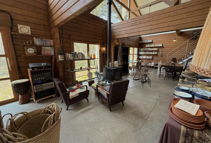This cozy coffee shop comes complete with an indoor / out door swing for the kids, a play area, a wood burning stove and a great sound system. The interior of a coffee shop with log burning stove and large speakers.