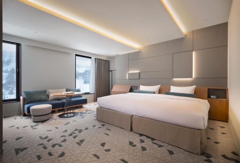 A double bed with windows to the left