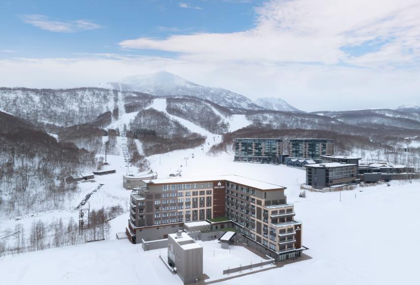 The exterior of an L shaped hotel amid a snowy back drop