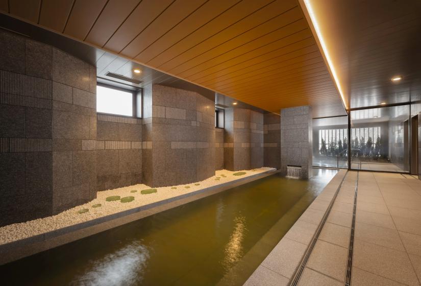 A long onsen bath with white pebbles on left side