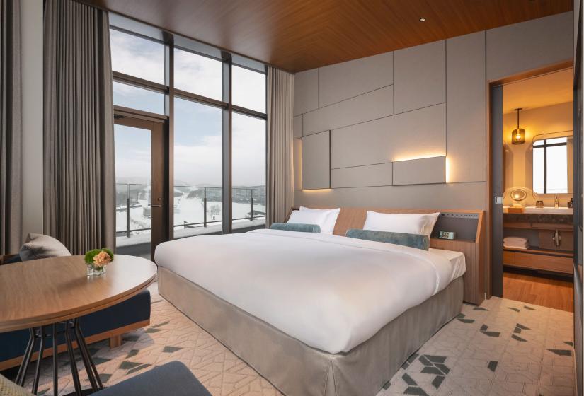 A large double bed with bathroom visible behind